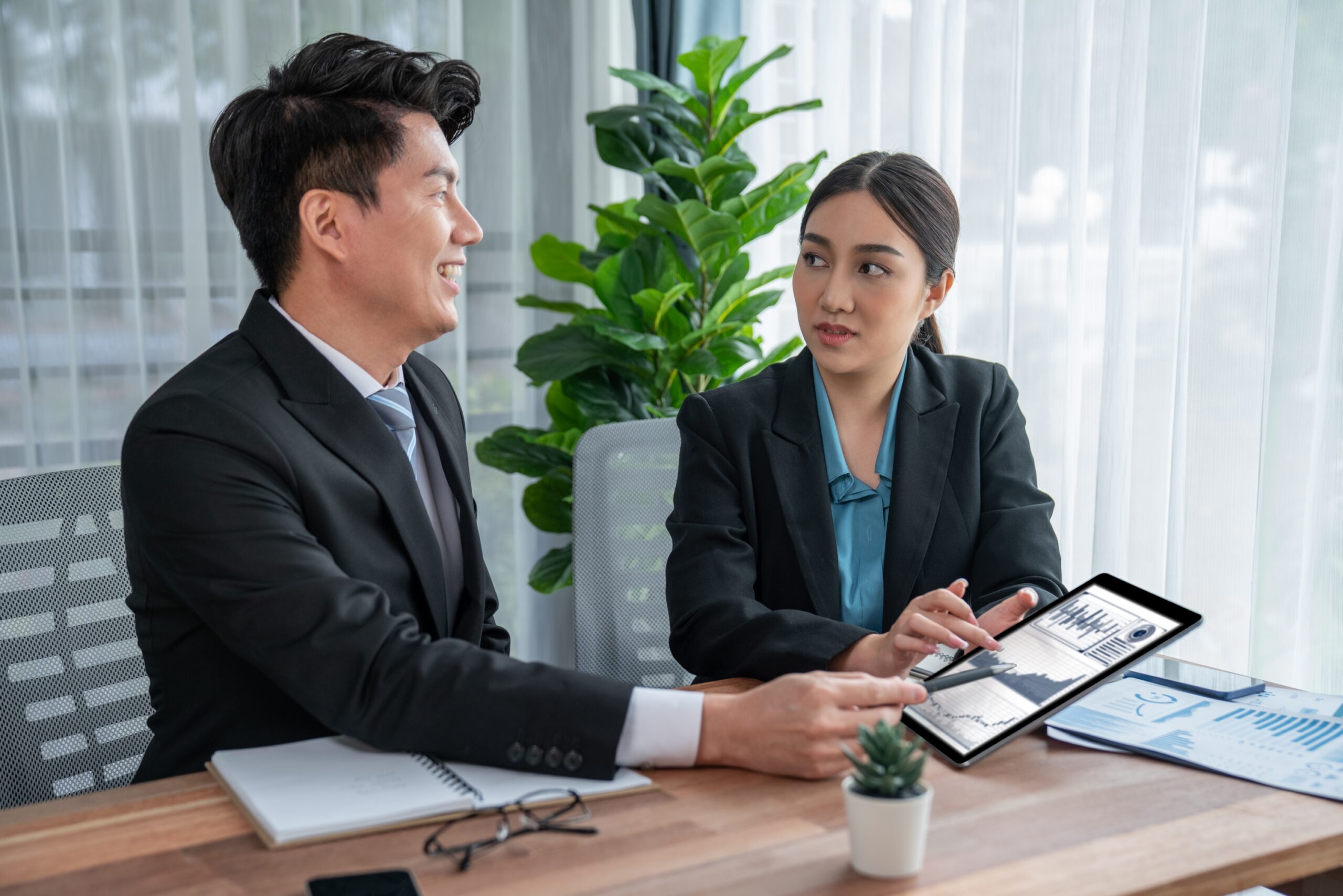 Busy analyst team in office discuss data analysis and marketing strategy using BI dashboard and statistics display on tablet screen to improve business performance at meeting with teamwork. Jubilant