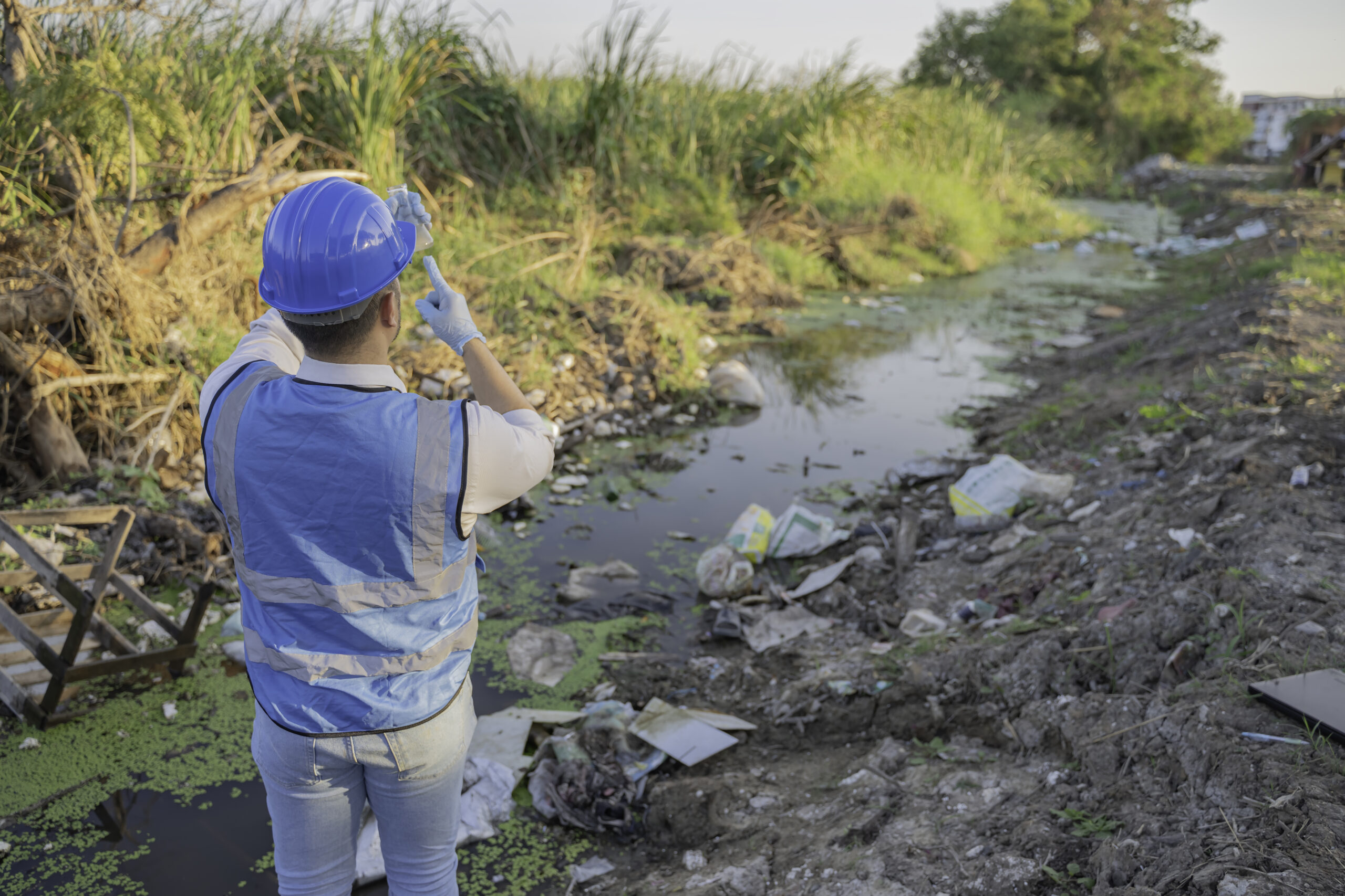 An Environmental Engineer Collects Water Samples from a Polluted Site, Analyzing Contaminants in Community Water Sources, Highlighting Waste Management and Environmental Protection Efforts