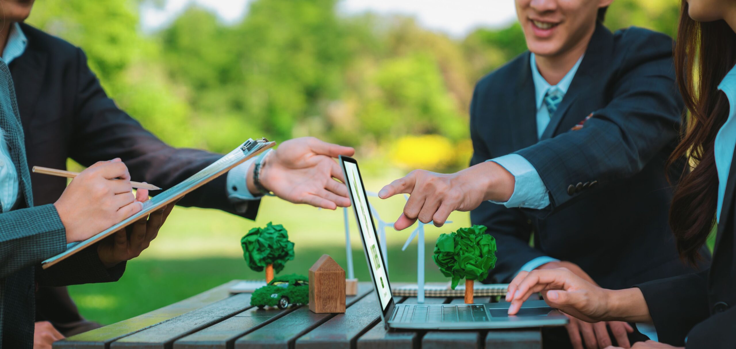 Group of asian business people presenting environmentally friendly development plan and sustainable technology project for greener future, establishing outdoor eco business office at natural park.Gyre