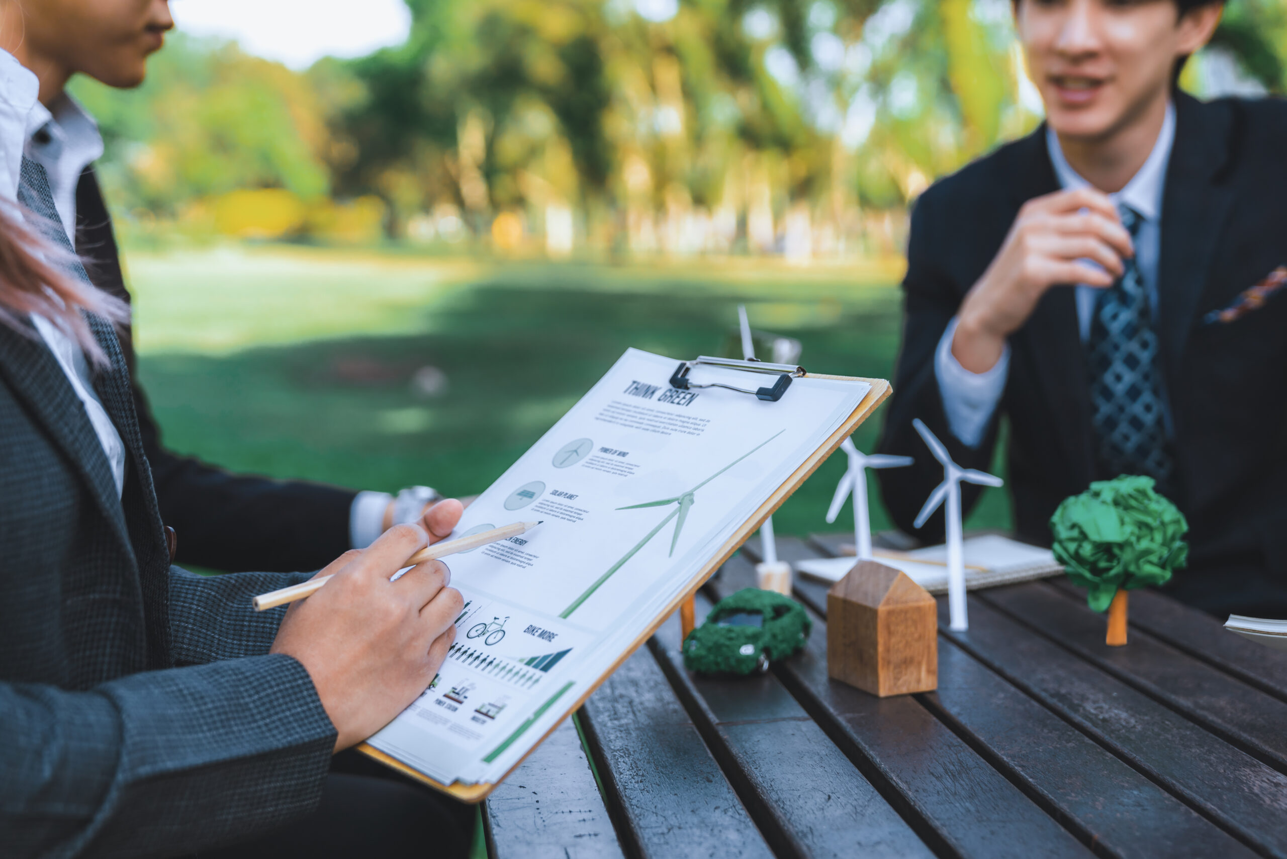Group of asian business people presenting environmentally friendly development plan and sustainable technology project for greener future, establishing outdoor eco business office at natural park.Gyre
