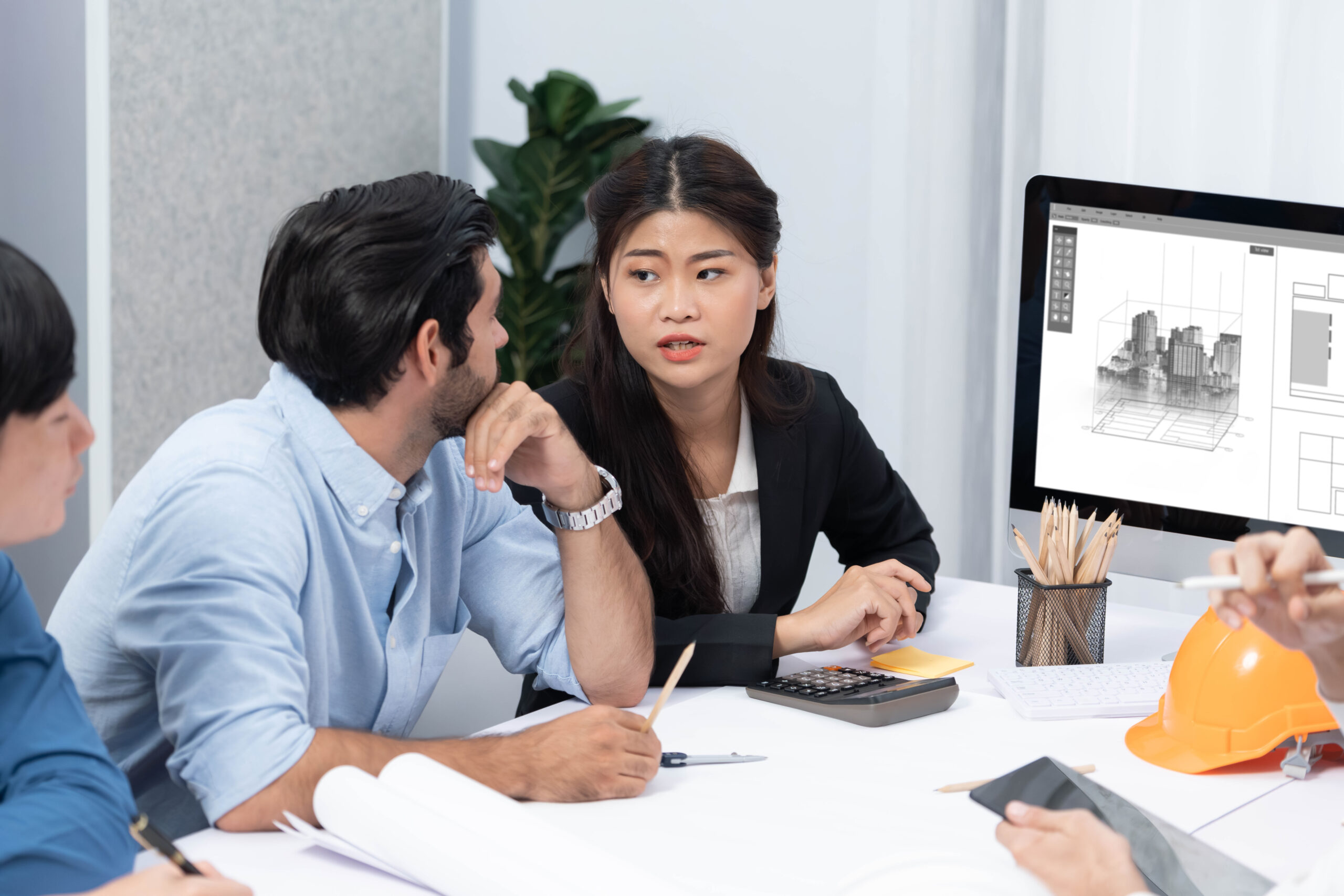 Diverse group of civil engineer and client working together on architectural project, reviewing construction plan and building blueprint at meeting table. Prudent