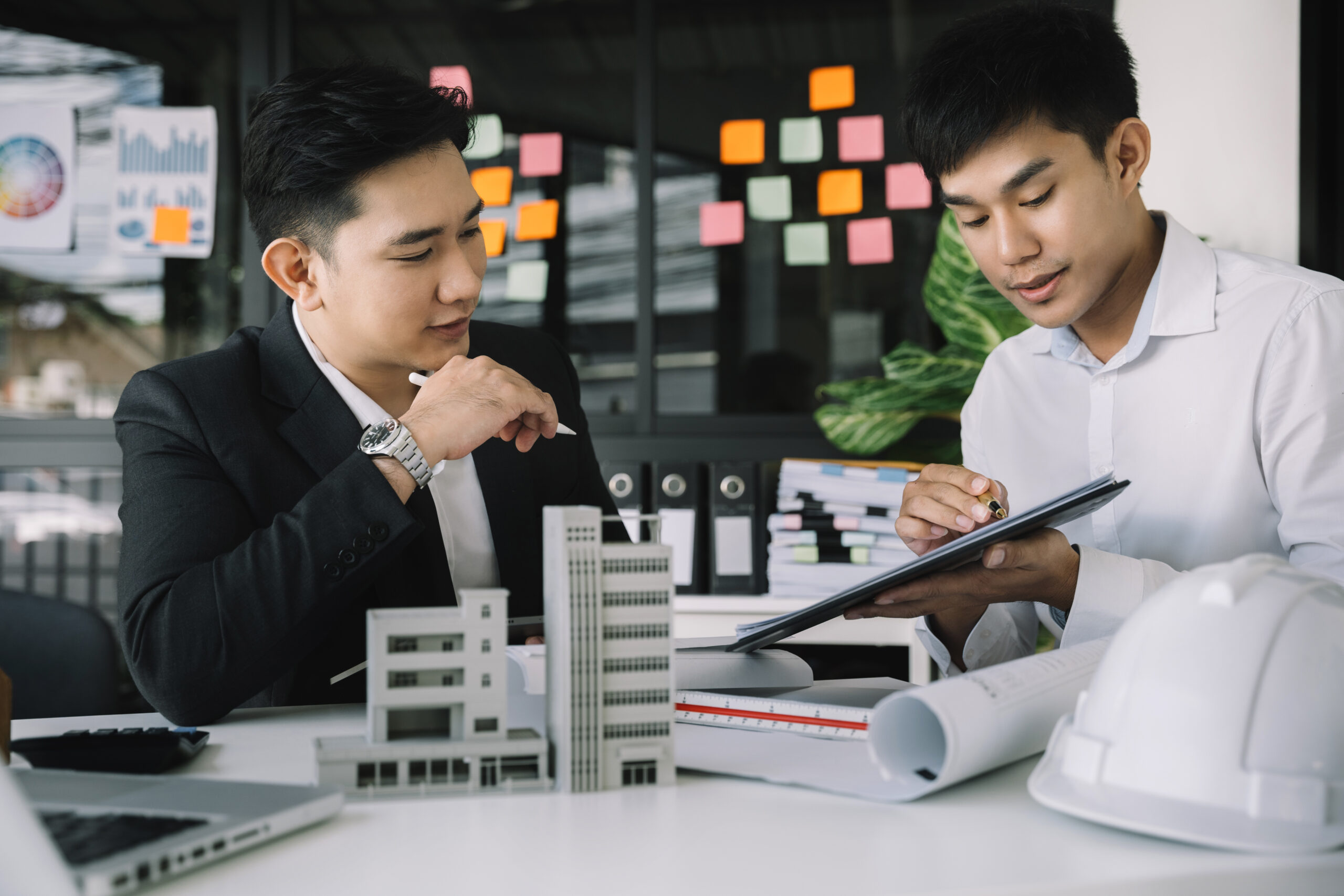 Working as a team architect and designer working on blueprint project of new apartments. Photo concept of work on technical drawings in office.